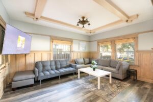 Spacious living room with 65 inch TV connected to dining room